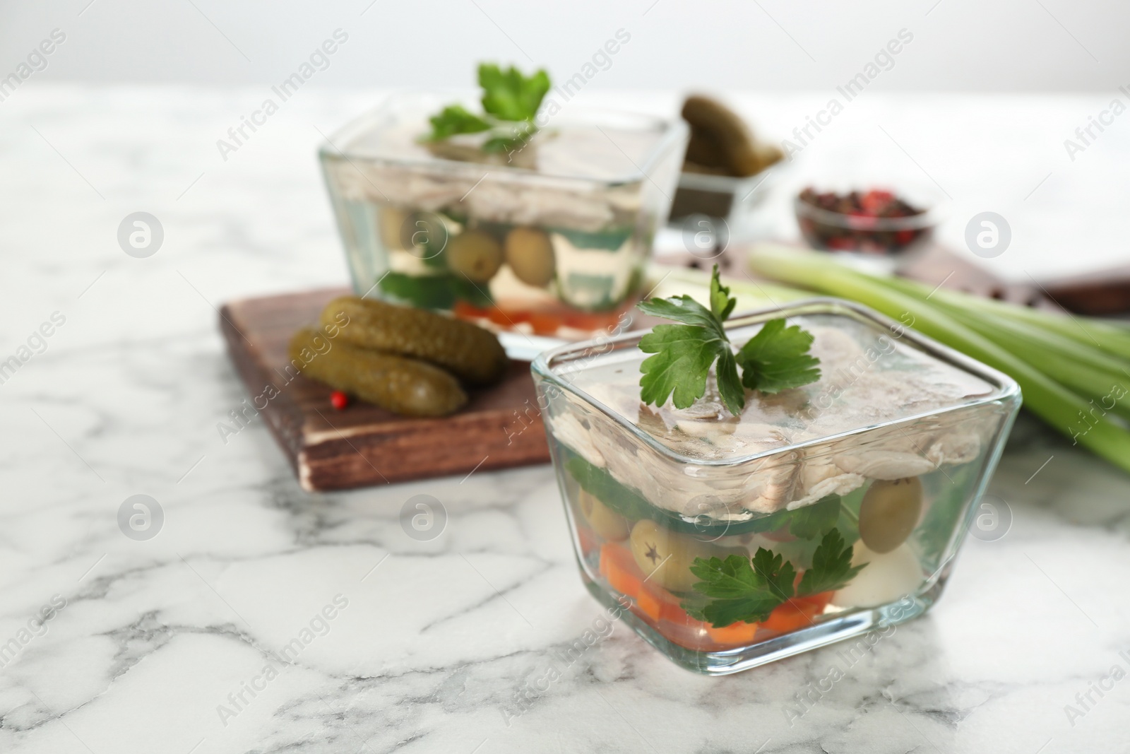 Photo of Delicious aspic with meat and vegetables served on white marble table