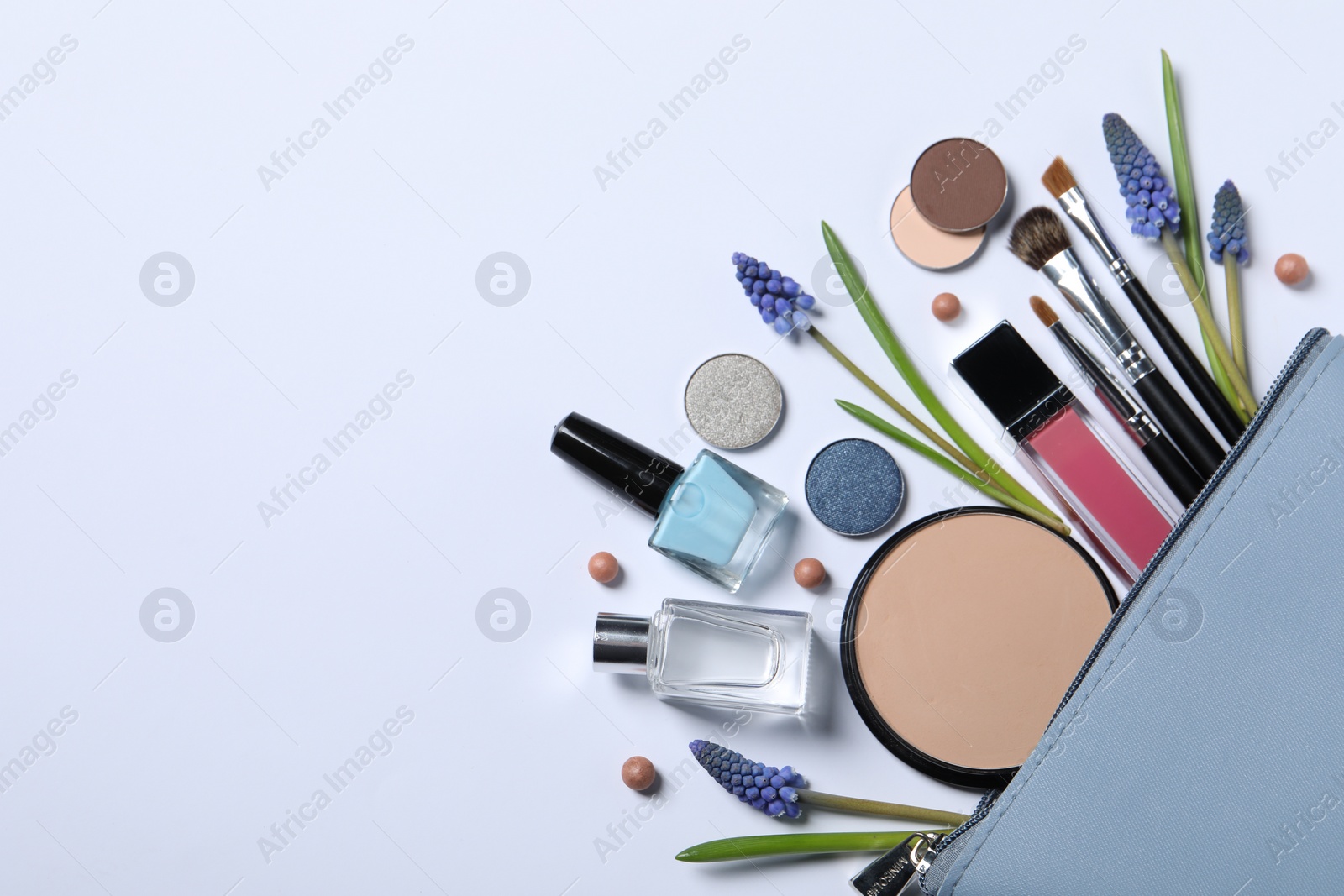 Photo of Flat lay composition with different makeup products and beautiful flowers on white background, space for text