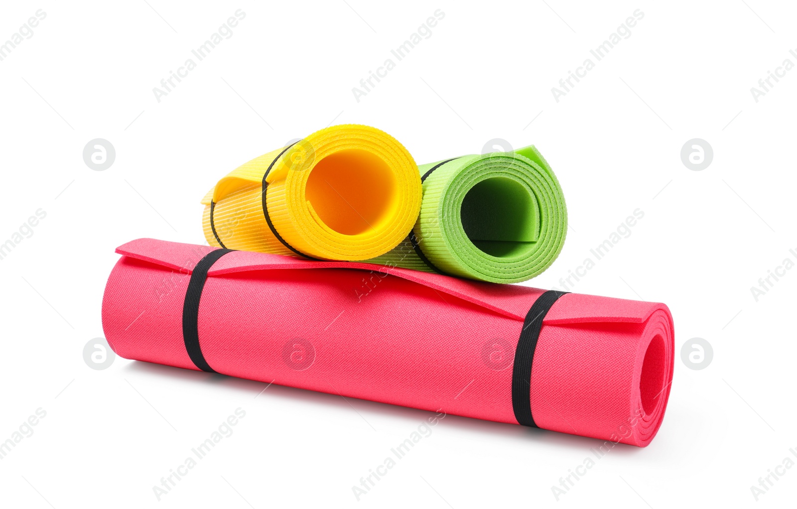 Photo of Colorful rolled camping or exercise mats on white background