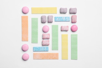 Photo of Different tasty colorful bubble gums on white background, flat lay