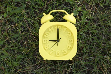 Photo of Alarm clock on green grass outdoors, top view