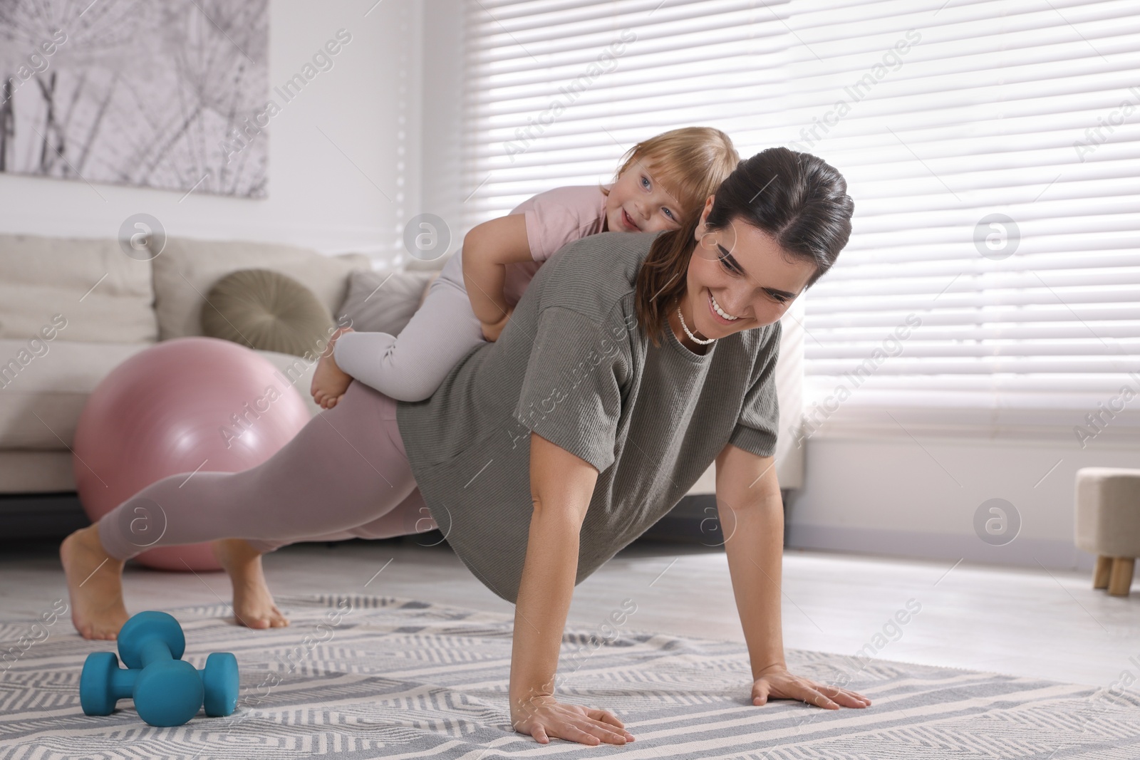 Photo of Mother doing exercise with her daughter at home