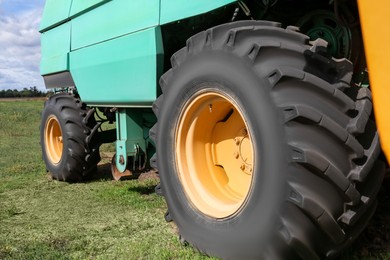 Photo of Modern combine harvester wheels outdoors, closeup view
