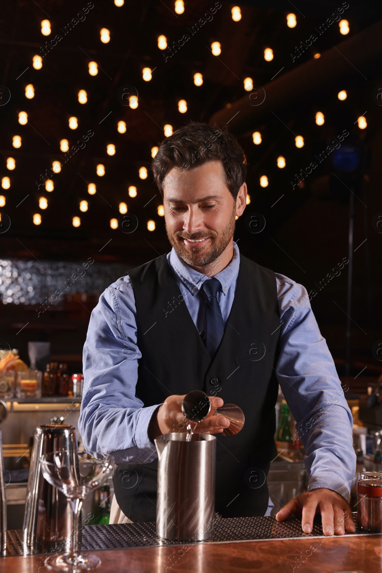 Photo of Bartender preparing fresh alcoholic cocktail in bar