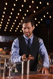 Photo of Bartender preparing fresh alcoholic cocktail in bar