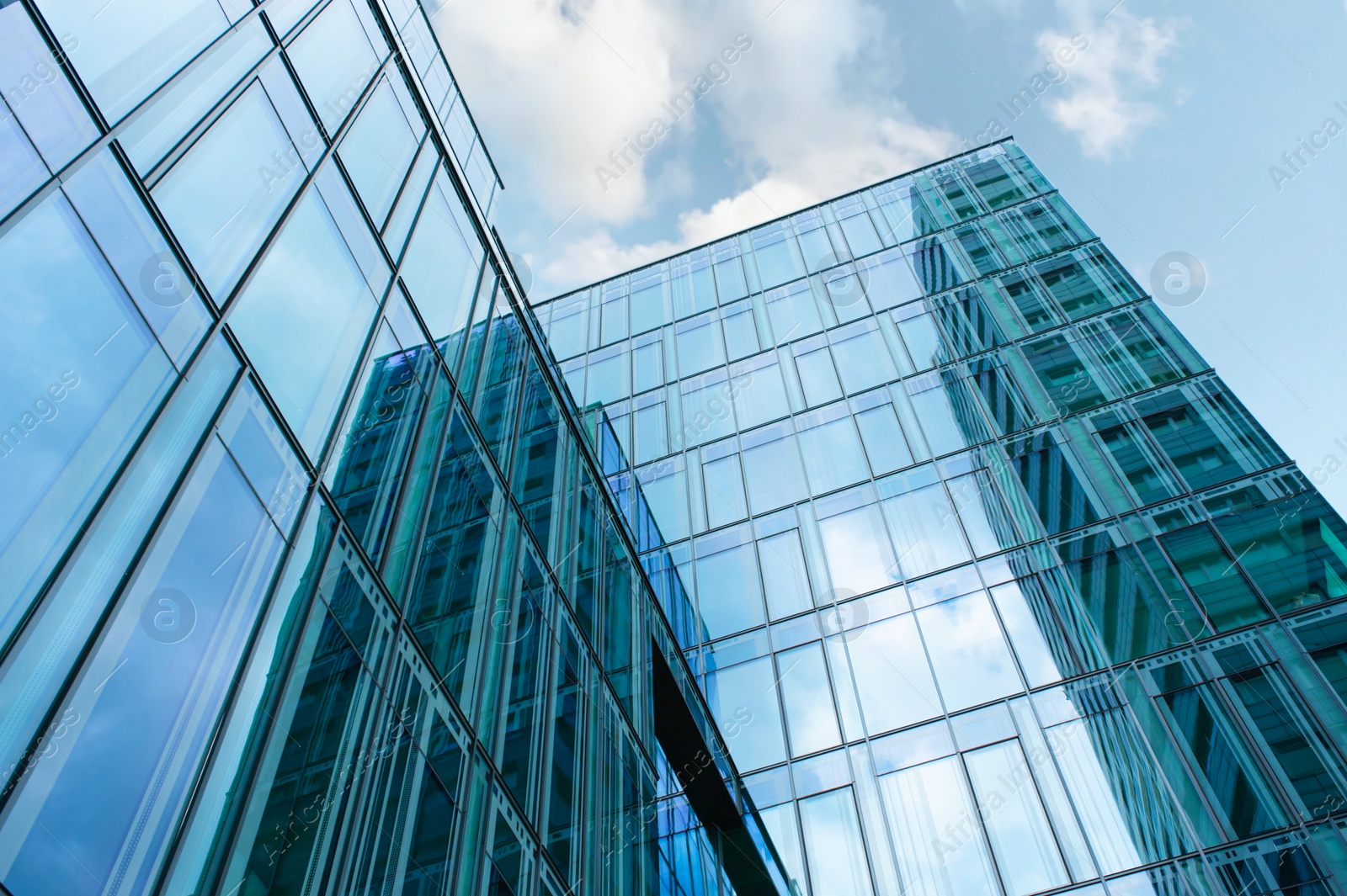 Photo of Stylish buildings with many windows under cloudy sky, low angle view