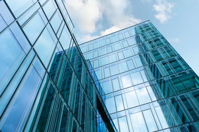 Stylish buildings with many windows under cloudy sky, low angle view