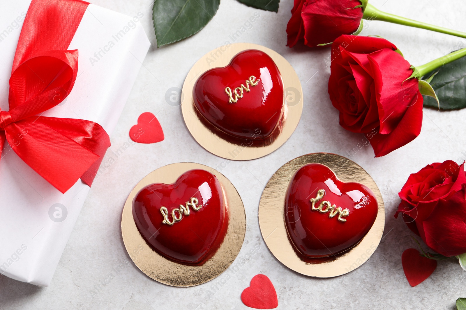 Photo of St. Valentine's Day. Delicious heart shaped cakes and roses on light table, flat lay