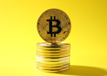 Stack of golden bitcoins on color background. Digital currency