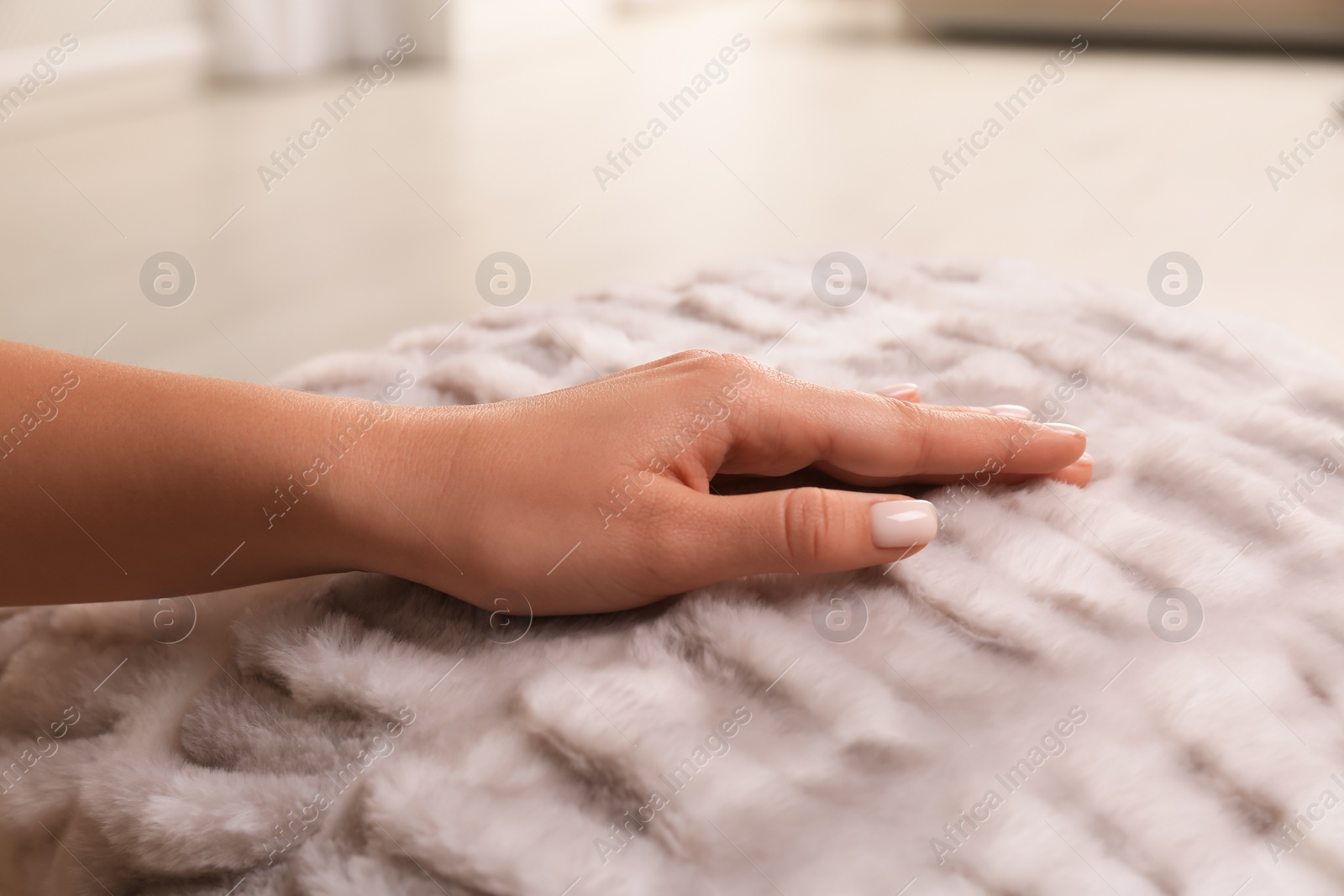 Photo of Woman touching soft fabric indoors, closeup view