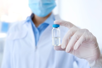 Photo of Female doctor with vial in hospital. Vaccination day