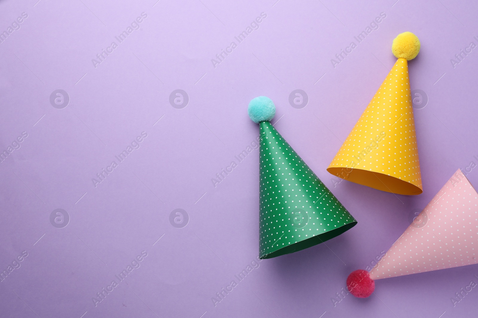 Photo of Beautiful party hats on purple background, top view. Space for text