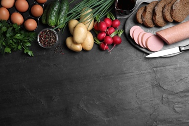 Flat lay composition with kvass and other okroshka ingredients on black table, space for text. Traditional Russian summer soup