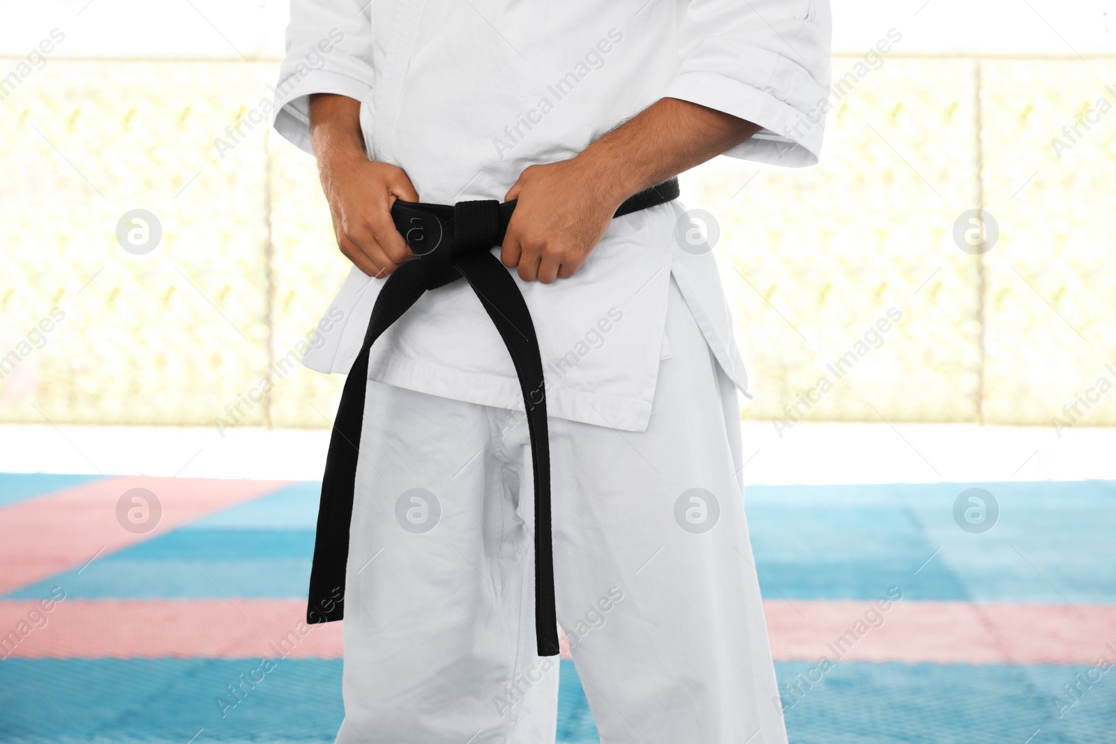 Photo of Karate coach wearing kimono and black belt at outdoor gym, closeup