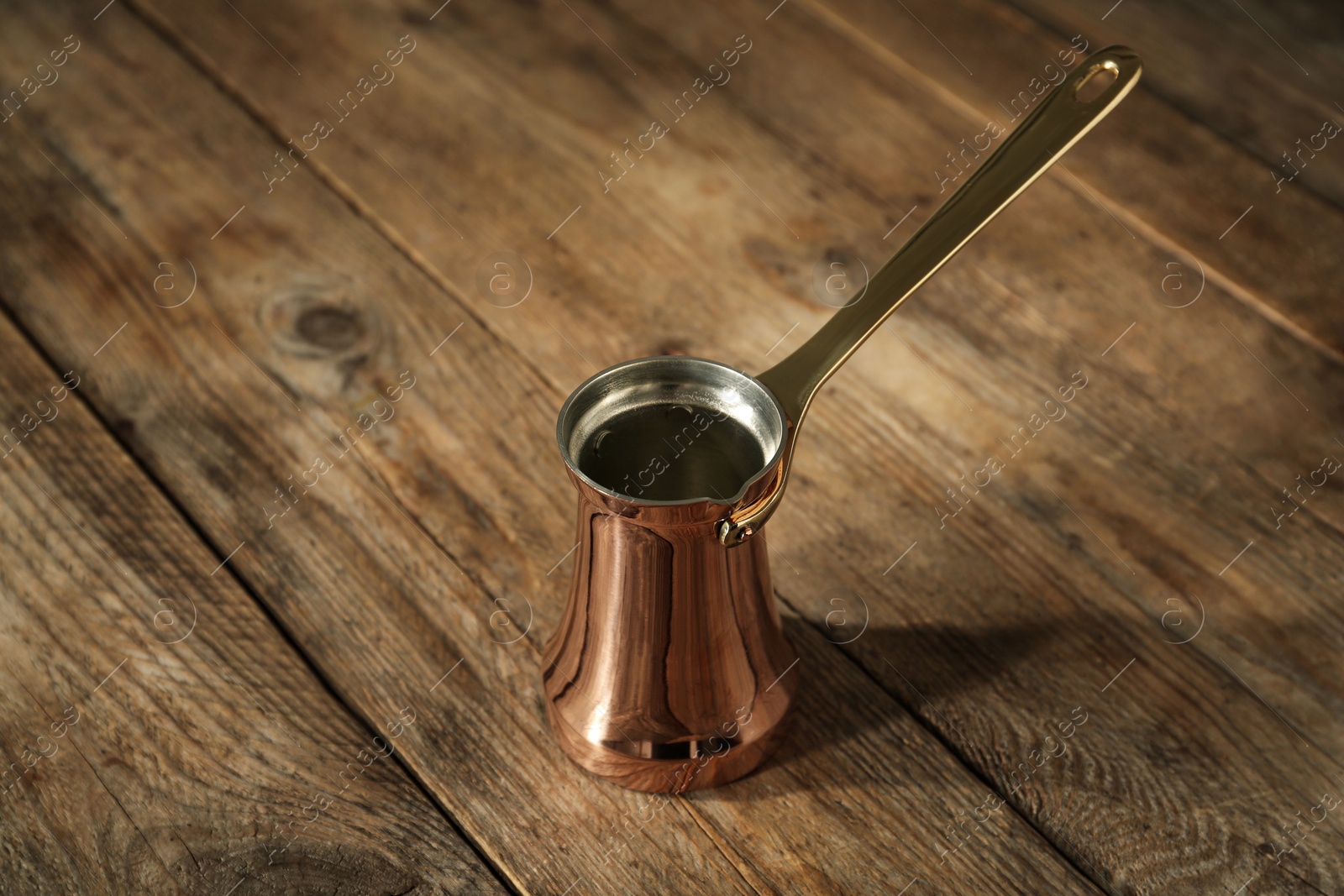 Photo of Beautiful copper turkish coffee pot on wooden table