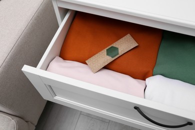 Scented sachet and folded clothes in drawer