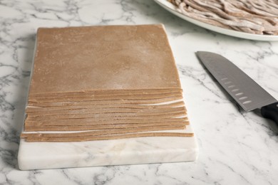 Photo of Making homemade soba (buckwheat noodles) on white marble table