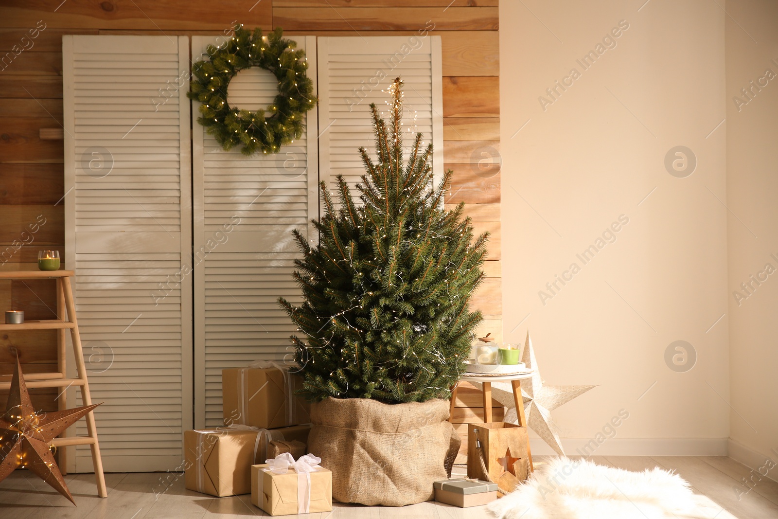 Photo of Spacious room interior with small Christmas tree and wreath