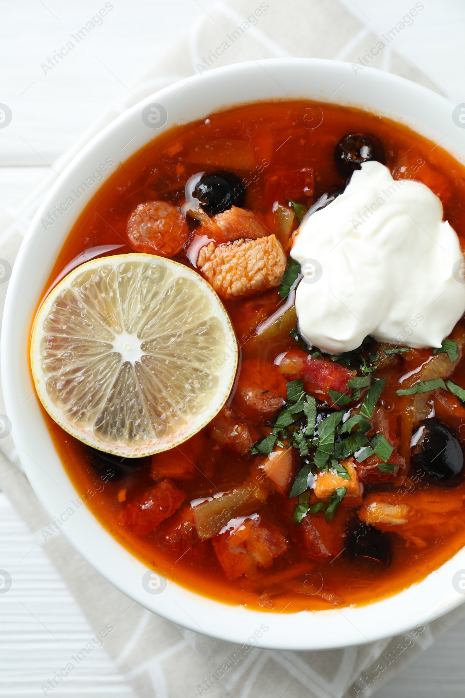 Photo of Meat solyanka soup with sausages, olives and vegetables on white table, top view