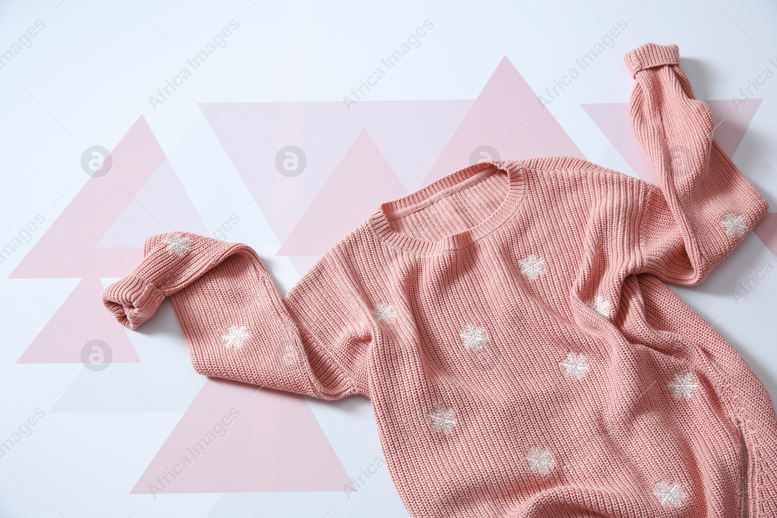 Photo of Top view of cozy knitted sweater on color background