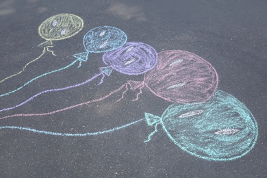 Photo of Child's chalk drawing of balloons on asphalt