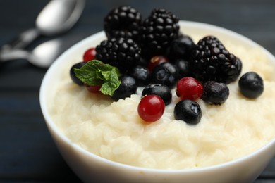 Photo of Delicious rice pudding with berries, closeup view