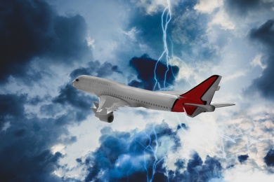 Airplane flying in cloudy sky during thunderstorm