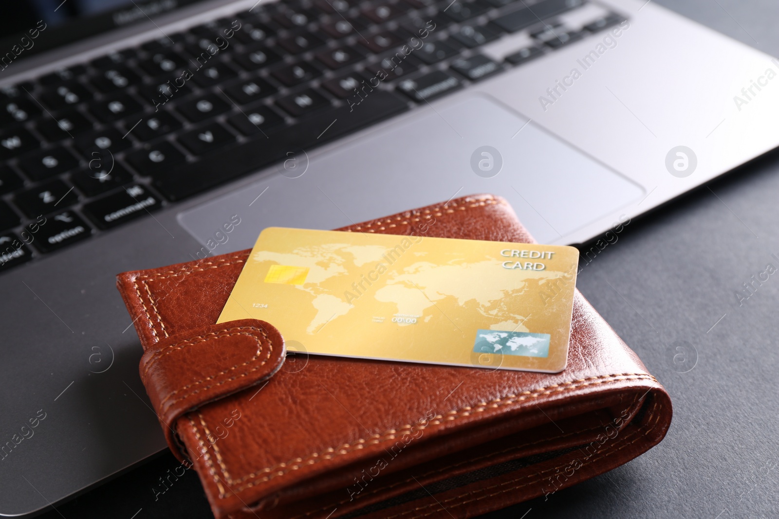 Photo of Credit card, laptop and leather wallet on grey table