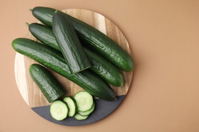 Fresh cucumbers on beige background, top view. Space for text