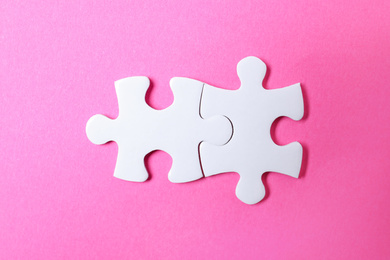 Photo of Blank white puzzle pieces on pink background, flat lay