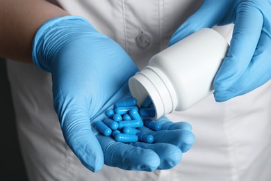 Photo of Doctor pouring pills from bottle onto hand, closeup view