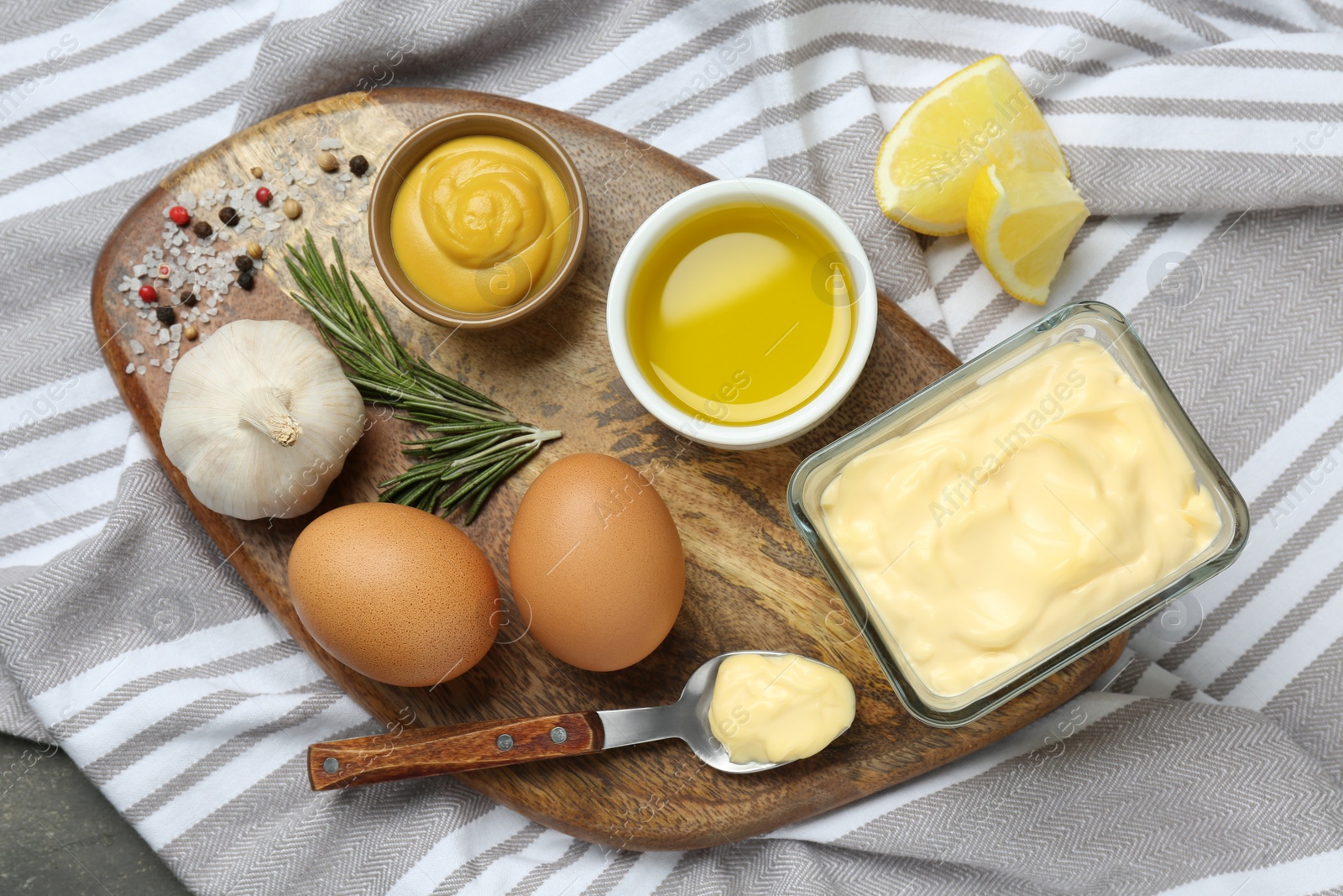 Photo of Delicious homemade mayonnaise, spices and ingredients on napkin, top view