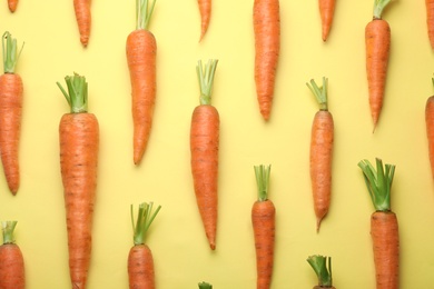 Flat lay composition with fresh carrots on color background