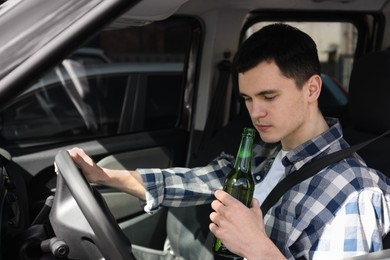 Man with bottle of beer driving car,. Don't drink and drive concept