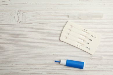 Photo of Disposable express hepatitis test kit on white wooden table, flat lay. Space for text