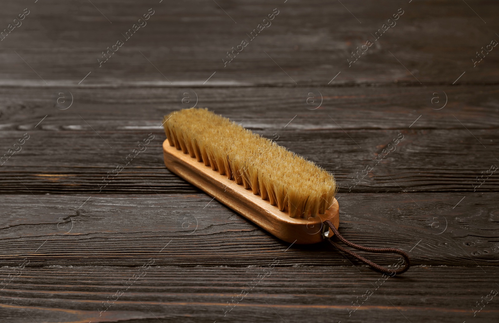 Photo of Shoe brush on wooden table. Footwear care item