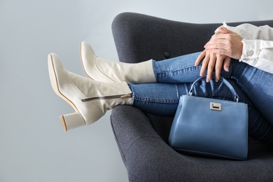 Woman wearing stylish leather shoes with bag indoors, closeup