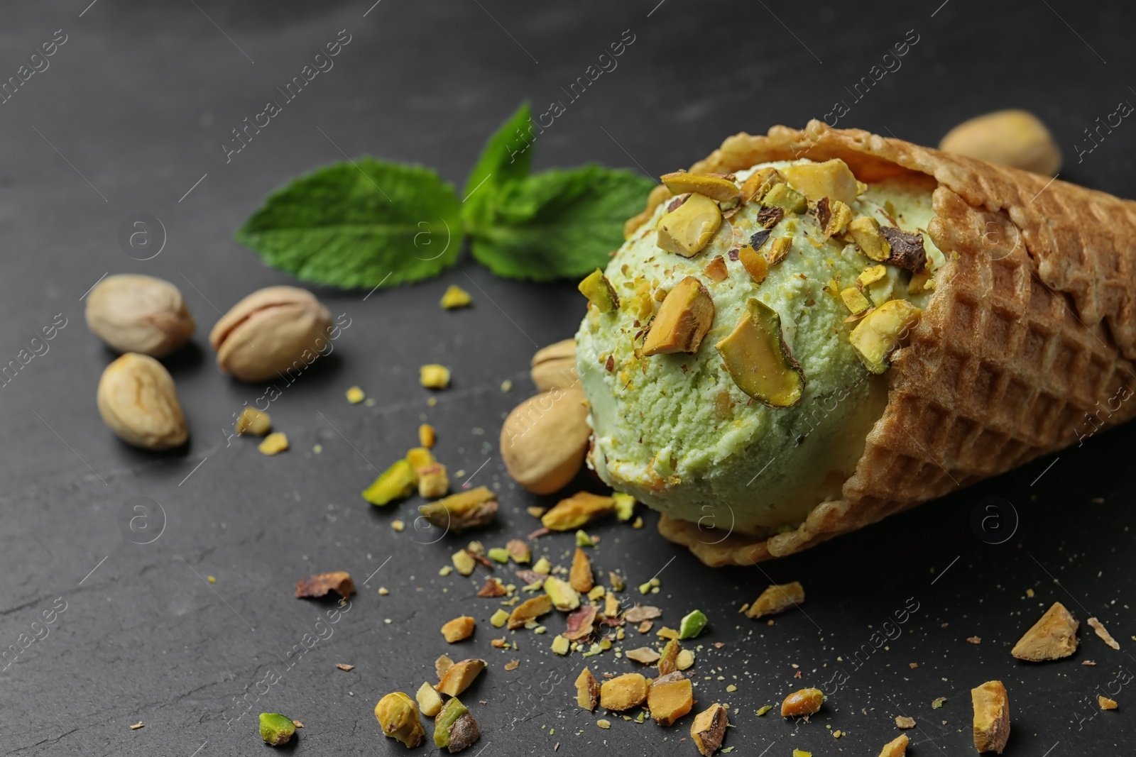 Photo of Delicious pistachio ice cream on dark table, closeup