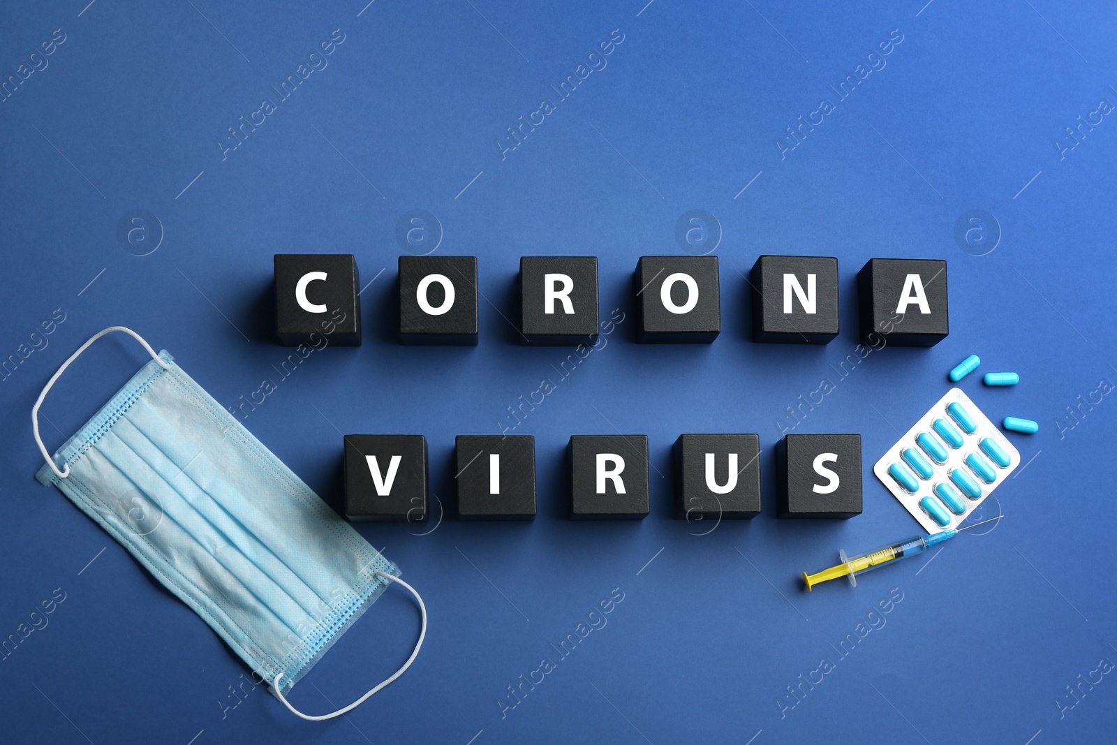 Photo of Wooden cubes with words CORONA VIRUS and medicine on blue background, flat lay