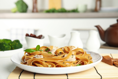 Photo of Tasty buckwheat noodles with meat served on kitchen table