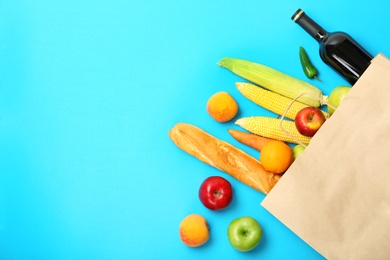 Flat lay composition with shopping bag and products on color background