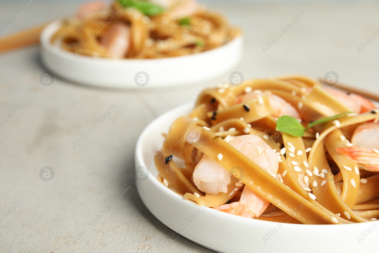 Photo of Tasty buckwheat noodles with shrimps served on light table, closeup