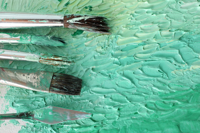 Photo of Abstract colorful artwork and brushes, closeup view