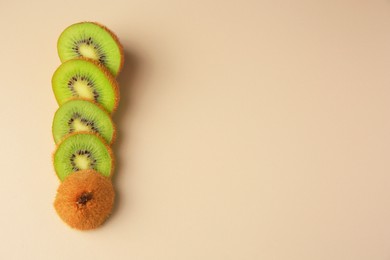 Sliced fresh kiwi on beige background, flat lay. Space for text