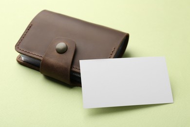 Leather business card holder with blank card on light green background