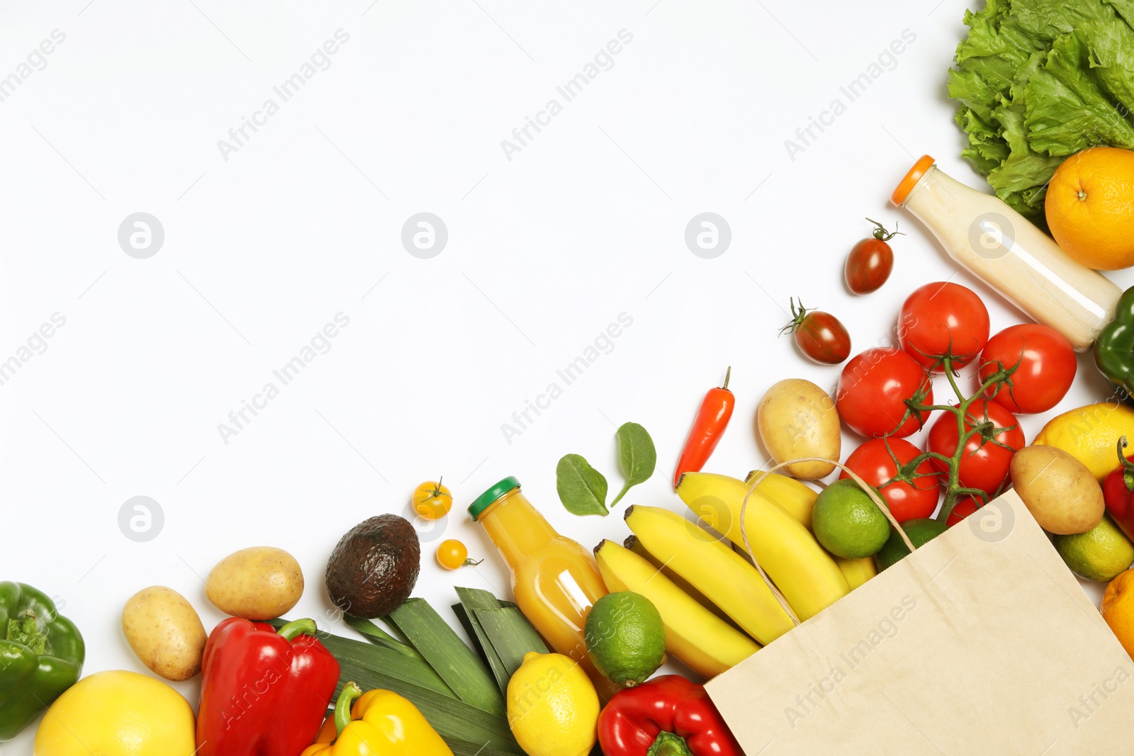 Photo of Shopping paper bag with different groceries on white background, top view