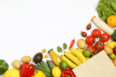 Shopping paper bag with different groceries on white background, top view