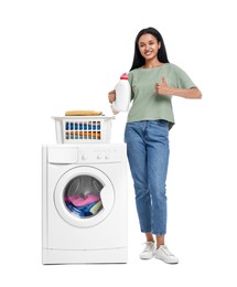 Photo of Beautiful woman with detergent showing thumb up near washing machine on white background
