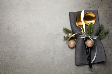 Photo of Cutlery set and Christmas decor on grey table, flat lay. Space for text