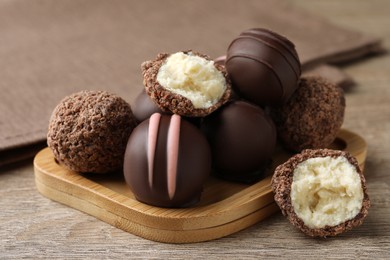 Photo of Many different delicious chocolate truffles on wooden table